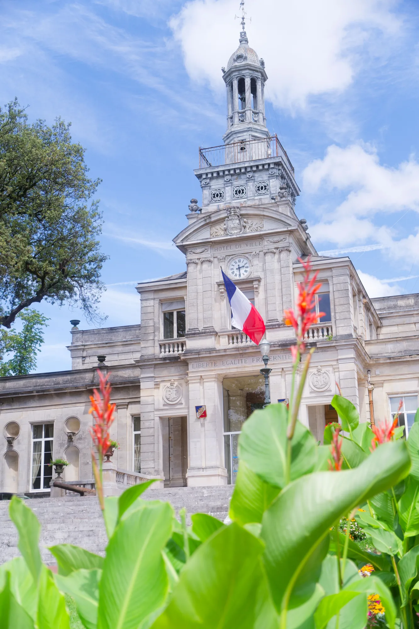 Façade d'un bâtiment de mairie avec drapeaux français et européen, symbole d'une collectivité territoriale