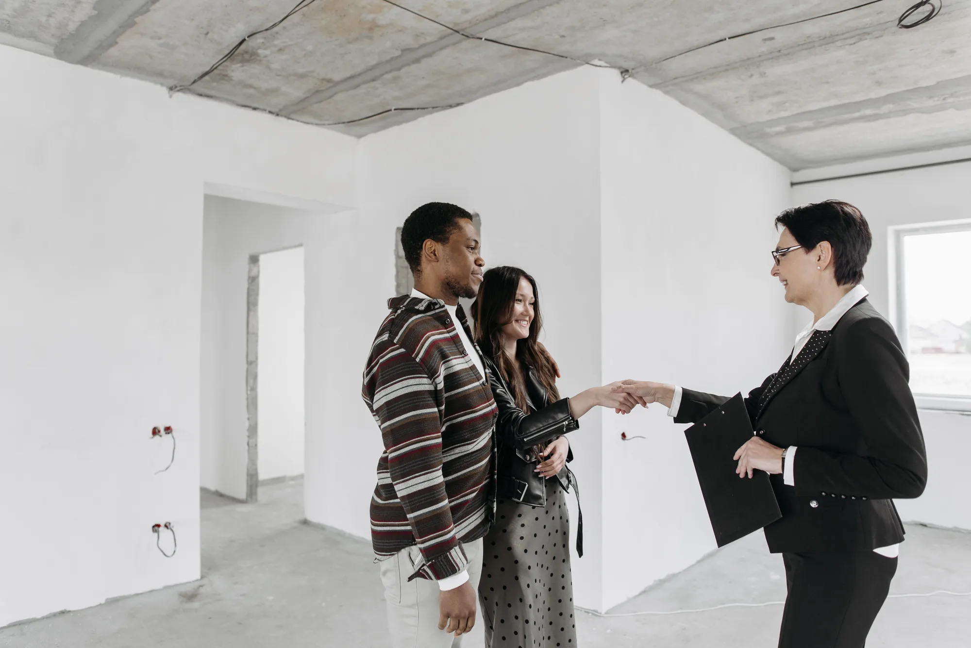 Agent immobilier présentant un bien à des clients, symbole des agences immobilières et mandataires
